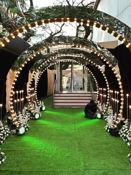 To create a glamorous and high-energy entrance for a Sangeet night, I used a series of arched mirror panels lined with retro-style bulbs. This creates a stunning tunnel of light and reflections that sets a celebratory mood from the moment guests arrive. The design is modern, chic, and perfect for an evening of music and dance.
