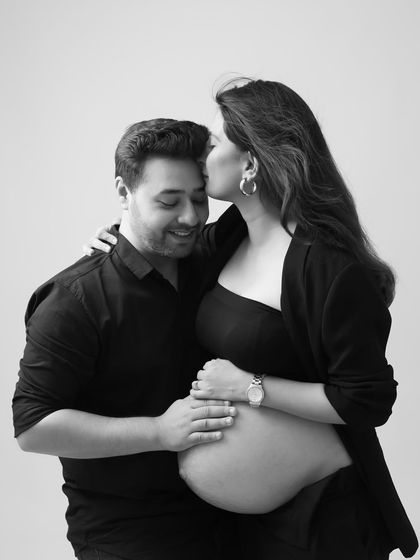 A sweet kiss on the forehead is a timeless expression of love. This black and white couple's portrait is full of warmth and tenderness.