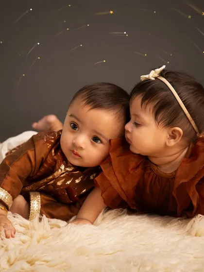 A secret between cousins. This adorable portrait captures a special moment between two baby cousins who were born on the same day, highlighting their budding friendship.