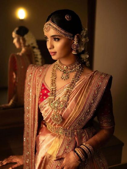 A beautiful shot of the bride looking into a mirror, her reflection capturing her regal elegance.
