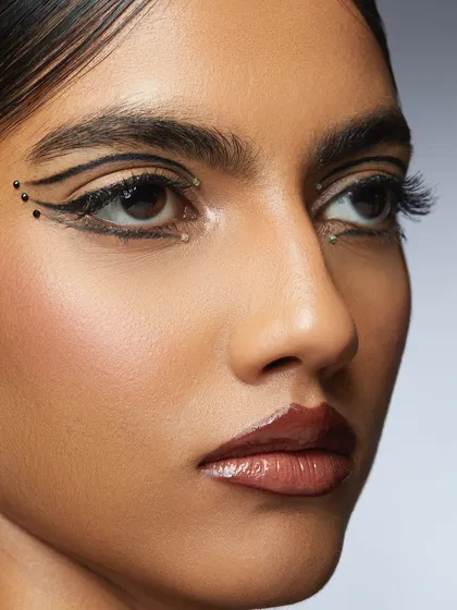 A close-up of a sleek and snatched graphic liner look, accented with tiny studs. This is precision work at its finest, created by a Delhi student.