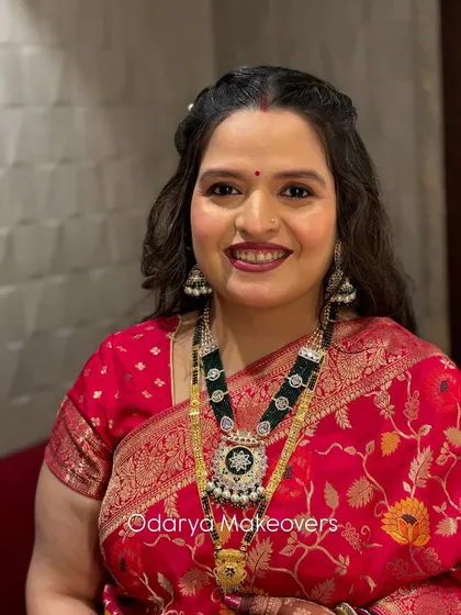 A close-up portrait from the naming ceremony. The makeup is flawless, with a bold lip that adds a touch of celebration.