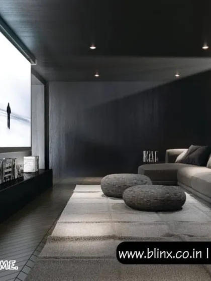 A minimalist and sleek design for a modern home. This theater uses a dark color scheme to maximize contrast for the large projection screen, with a low profile media console and comfortable sectional sofa creating a clean and uncluttered viewing space.