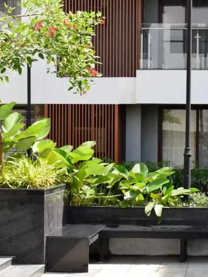 The careful placement of planters and benches within the Sona Vistaas residential cluster creates intimate, human-scaled spaces. This approach to landscape design enhances visual comfort and encourages informal social interactions.