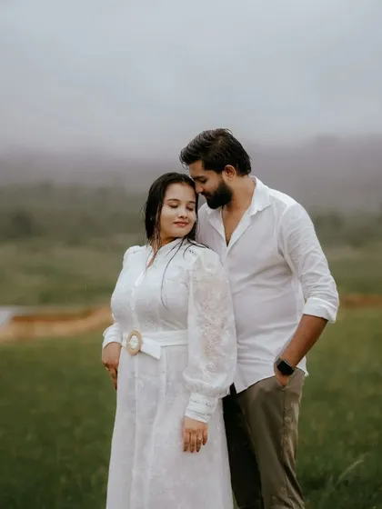 A gentle, intimate portrait taken during a misty morning shoot. The soft light and foggy background create a serene and romantic setting, focusing purely on the couple's connection.