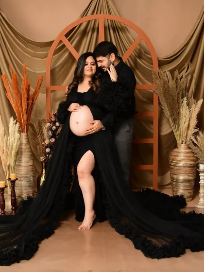A dramatic and romantic couple's portrait featuring a gorgeous black ruffled gown. We posed the couple against our earthy, boho-inspired backdrop with pampas grass to create a moody yet intimate pregnancy photograph.
