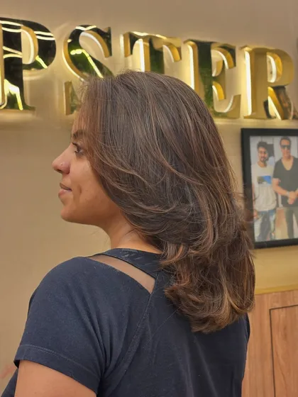 A three-quarter view of a client's new hair color and style. The layers and highlights work together to create a look full of volume and life.