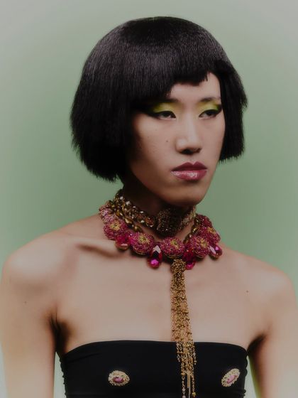 This shot shows how a statement necklace can be layered with a bandeau top. The styling is modern and high-fashion.