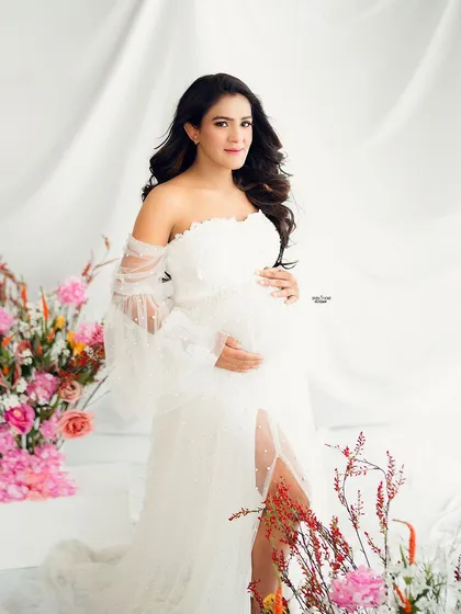A full-length portrait of this ethereal floral setup. The combination of the white gown and the vibrant flowers is breathtaking.