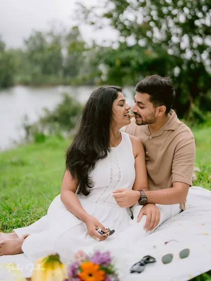 A lakeside picnic for two. These relaxed pre-wedding sessions are perfect for capturing genuine smiles and easy-going interactions, just like this moment shared between the couple.