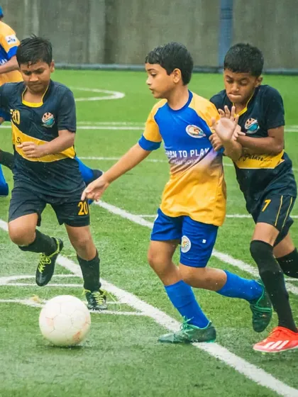 Two of our U13 players battling for the ball during a rainy Thane Youth League match.