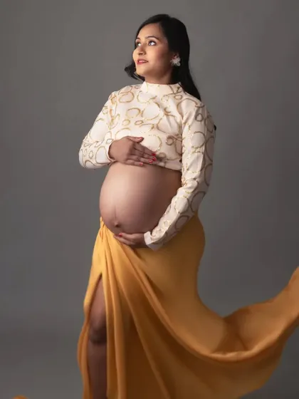 A close-up of this elegant look, focusing on the beautiful baby bump. The way she holds her belly shows such tenderness and love.