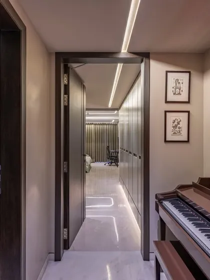 A duplicate of image 27, this view emphasizes the corridor as a gallery space. The linear ceiling lights guide the eye through the home, connecting the public and private areas.