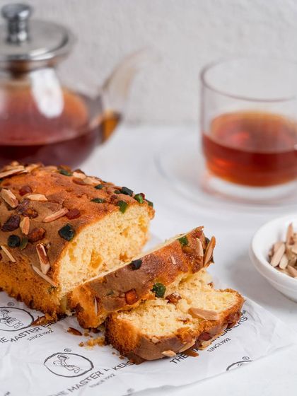 A slice of our fruit and nut dry cake is the perfect companion to a cup of tea. This simple, elegant shot captures the joy of a sweet moment, crafted by us since 1992.