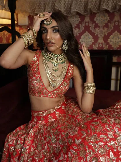 A powerful pose showcasing the intricate jewellery and the detailed embroidery of the lehenga. This look is for the bride who wants to feel like a queen.