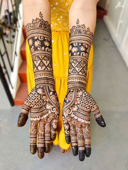 This bridal design features beautiful bands of lotus motifs and criss-cross patterns. The contrast between the filled and empty spaces makes the floral work pop.