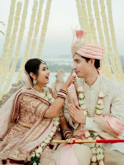 A playful and candid moment during the wedding ceremony. The bride lovingly teases the groom, showcasing their comfortable and joyous connection even during the formal rituals.