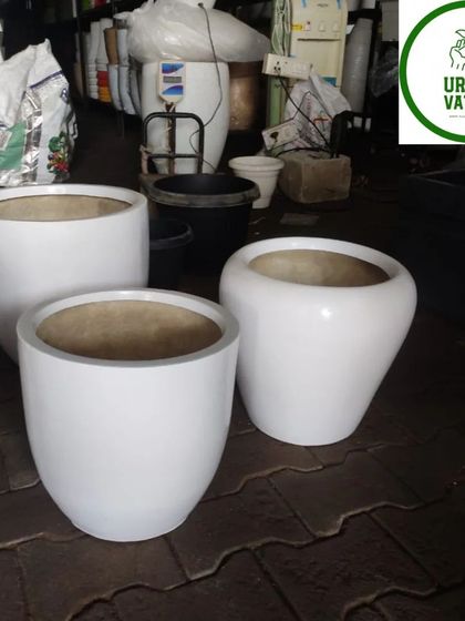 A set of modern, rounded white pots.