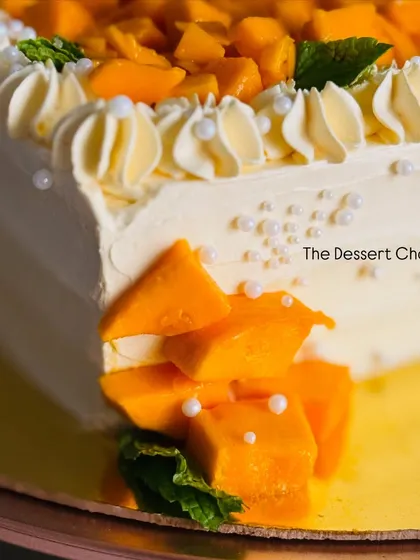 A detail shot of the fresh mangoes spilling over the side of this delicious seasonal cake.