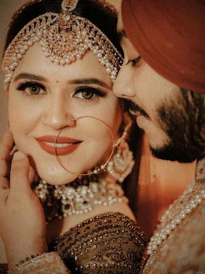 A stunning close-up of the couple, the groom's gentle touch on the bride's face highlighting their intimacy and love.