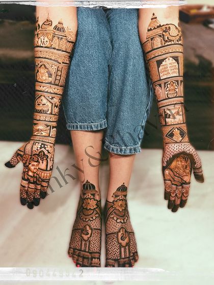 A complete head to toe bridal mehndi look. This photo shows the coordinated design on the hands, arms, and feet, creating a cohesive and stunning bridal statement.