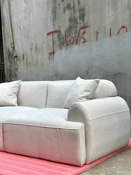The rounded arms and piped seams of this modern sofa are highlighted in this shot.