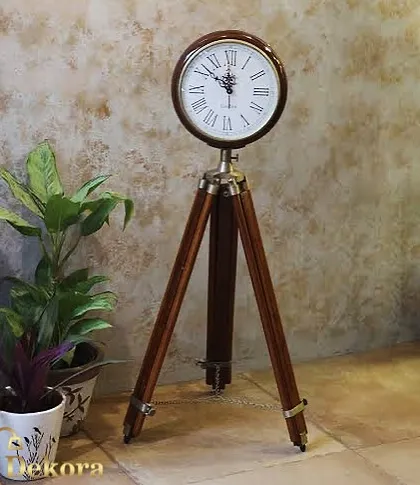 This vintage-inspired tripod clock is a standout piece for any room. The design features a classic Roman numeral clock face set upon an adjustable wooden tripod with metal accents, blending nautical and industrial decor styles.
