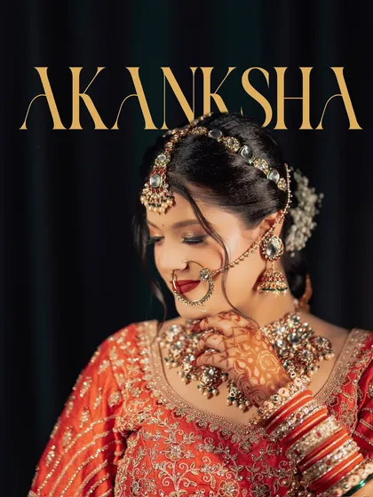A graceful close-up portrait of the bride, Akanksha. Her gentle smile and the way she touches her necklace create a soft, contemplative mood, beautifully capturing her pre-ceremony moments.