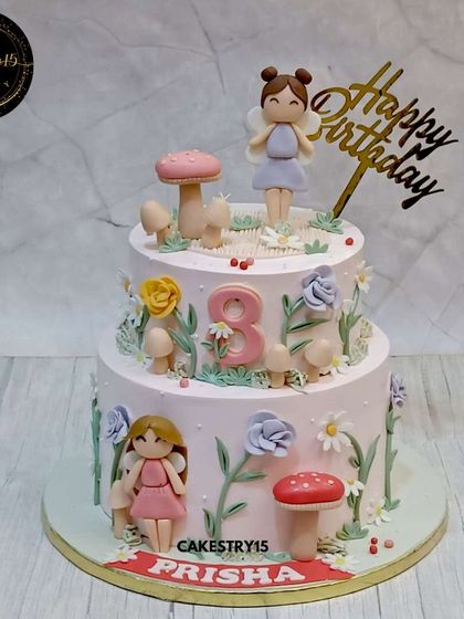 An enchanted fairy garden cake for an eighth birthday. This two-tier chocolate cake is decorated with delicate fairy figurines, fondant mushrooms, and beautiful sugar flowers, creating a whimsical woodland scene.