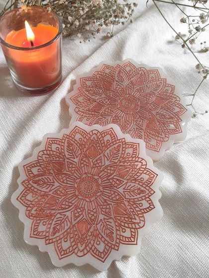 I love the intricate detail in these mandala coasters. This design is etched in rose gold on a pearly white base, creating a peaceful and artistic look.