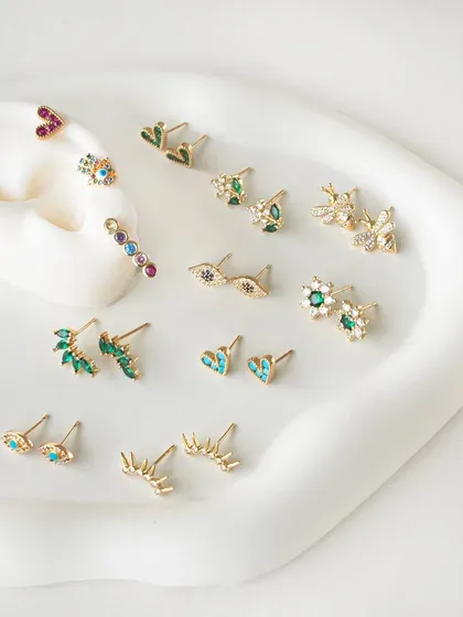 A wider view of my new earring sets, featuring a variety of evil eye, floral, and gemstone designs.