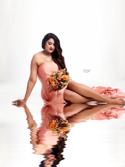 A lovely portrait focusing on the client's serene expression as she sits in a beautiful peach gown. The water reflection adds a unique, artistic touch to this simple and elegant shot.