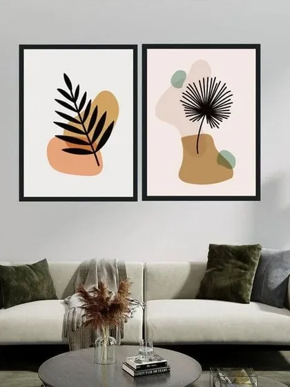 This set of two framed prints features botanical illustrations in a minimalist style. The simple leaf and plant forms against neutral abstract shapes create a calm and modern aesthetic.