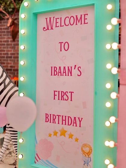 A close-up of the light-up marquee welcome sign for Ibaan's first birthday. The warm lights and fun font create a festive and personalized greeting for guests.