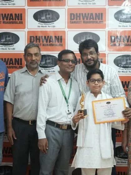 A family photo celebrating their son's achievement in our art program.