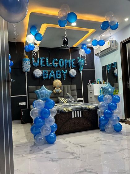 The full view of the 'Welcome Baby Boy' room, with balloon columns and ceiling decorations.