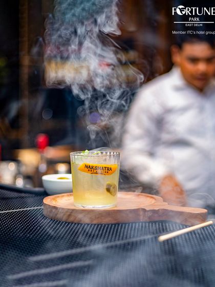 Our signature smoked cocktail, presented with a flourish. The aromatic smoke adds a unique dimension to the drink, making it a multi-sensory experience.