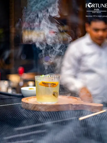 Our signature smoked cocktail, presented with a flourish. The aromatic smoke adds a unique dimension to the drink, making it a multi-sensory experience.
