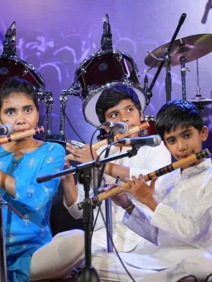 A trio of young flautists playing in harmony, a result of dedicated group practice sessions.