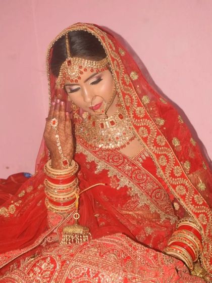 A traditional pose showing the bride's full attire, including her henna and bangles. The makeup ties the entire look together.