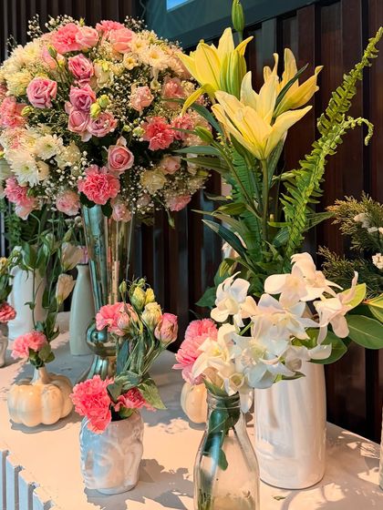 Detail shot of the fresh flowers used in the Roka decor. The combination of pink carnations, yellow lilies, and white orchids adds a touch of freshness and elegance to the console table.