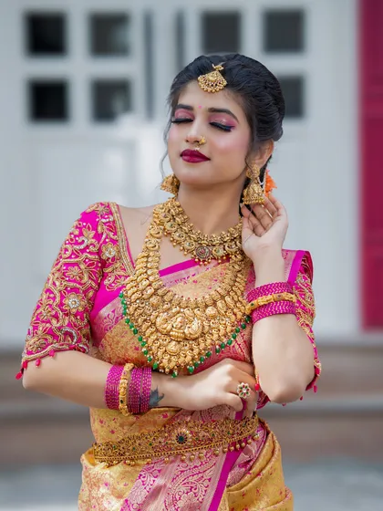 A beautiful portfolio piece by one of my students, featuring a pink and gold bridal look with heavy temple jewellery.