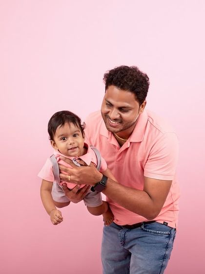 A playful moment between a father and his baby. Capturing these dynamic, interactive shots adds energy and joy to a family's gallery.