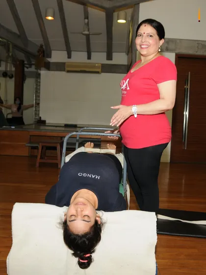 Pain drains your energy and positivity. This image shows a supported restorative pose that helps calm the nervous system and alleviate back pain, a cornerstone of my medical classes.