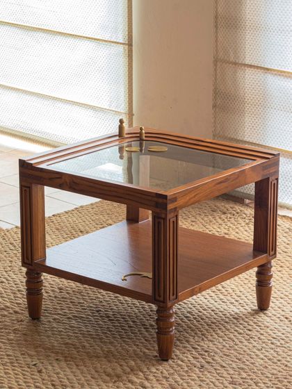 Different views of the Kulam collection, including the side table and center table. These images showcase the blend of solid teak, glass, and narrative brass accents that define this collection.