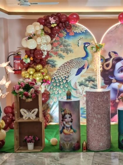 Another angle of the Radha Krishna themed baby shower, showing the peacock prop and floral details.