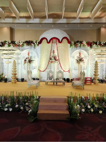 A classic mandap design featuring a dome-shaped floral canopy made of jasmine and rose strings. The white and red color palette offers a timeless and traditional look for the ceremony.