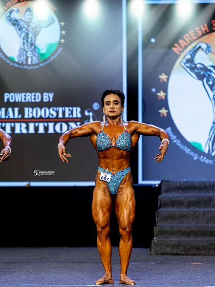 The front lat spread, demonstrating width and a V-taper. This is a crucial pose for scoring high in women's physique.