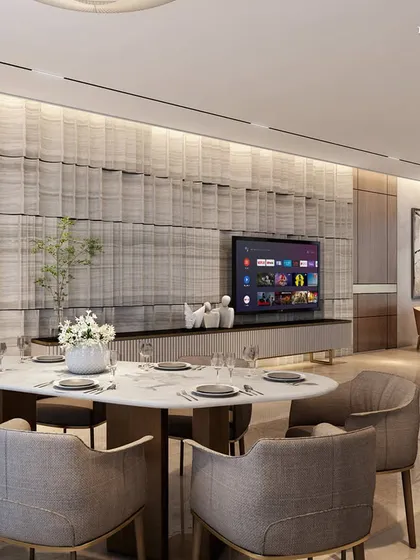 The living and dining areas of this Nagpur apartment are designed as a sanctuary from the bustling world outside. A fluted marble feature wall behind the television creates a textured focal point, complemented by neutral furnishings and warm wood accents for a serene atmosphere.