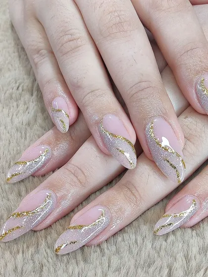 An elegant and sparkling design. A sheer pink base is adorned with sweeping lines of gold glitter, creating a glamorous and dynamic look.